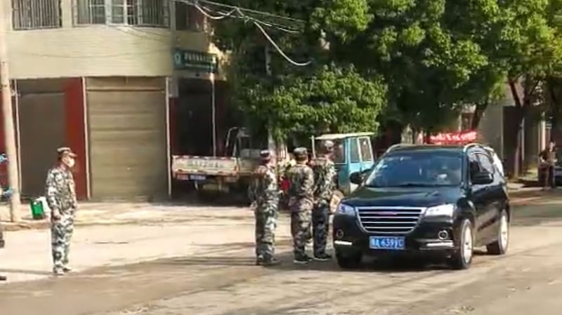 武汉新洲,保安人员驱赶上街的民众。(视频截图/乔龙提供)